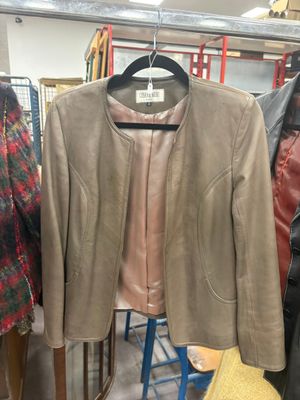 leather jacket on a hanger in a clothing store next to a hat