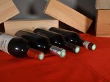 several bottles of wine are lined up on a red table cloth