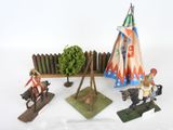 several figurines of native americans are displayed on a white surface