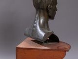 bronze bust of a woman on a wooden stand