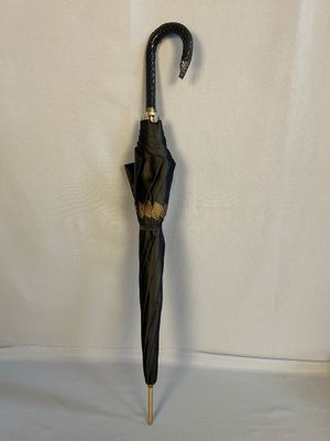 un parapluie noir posé sur une surface blanche