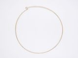 un collier en or orné d'une seule perle sur fond blanc