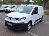 une camionnette blanche garée dans un parking à côté d'autres camionnettes