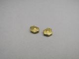 a pair of gold plated hexagonal earrings on a gray surface