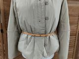 jacket on a mannequin stand in front of wooden shutters