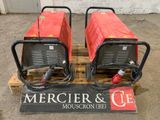 deux appareils de soudage rouges posés sur une palette dans un entrepôt