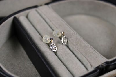 a pair of earrings sitting in a case on a table