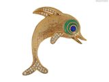 une image représentant une broche en forme de dauphin en or, avec un œil bleu et vert