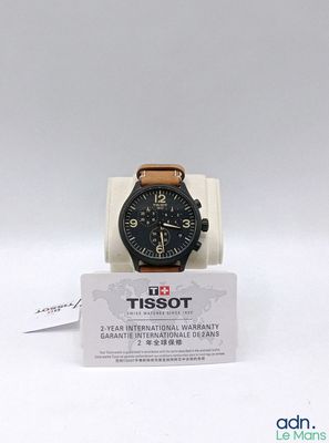 une montre noire avec un bracelet en cuir marron