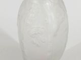 un vase blanc avec un socle rose sur fond blanc