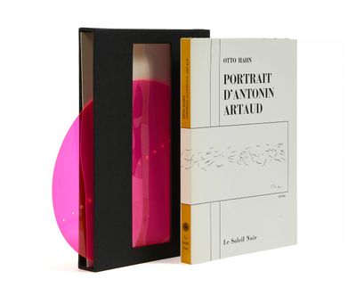 un objet rose dans une boîte noire à côté d'un CD rose