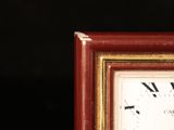 a small clock with roman numerals on the face