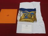 an orange box with a blue scarf and a gold pillow on a red table