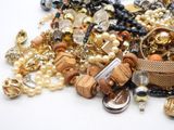 a pile of assorted jewelry on a white surface