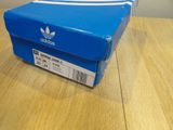 a box of adidas shoes sitting on a wooden table