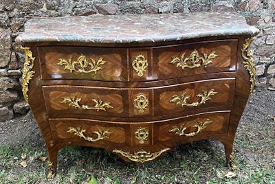 une commode au plateau en marbre, installée dans un espace aux murs en pierre