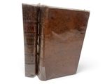un livre marron ouvert sur une surface blanche