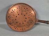 an antique copper frying pan with a handle and handle
