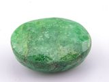 a close up of a green stone on a white surface