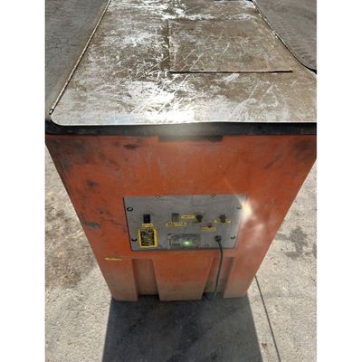 une boîte métallique posée sur le trottoir, avec un bouton jaune