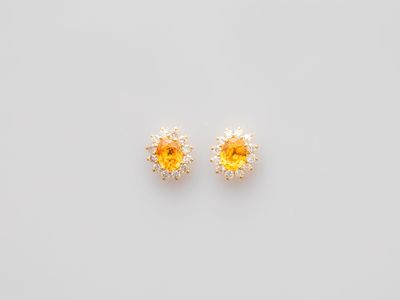 a pair of yellow sapphire and diamond earrings on a white background