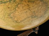 an old globe on a stand with a black background