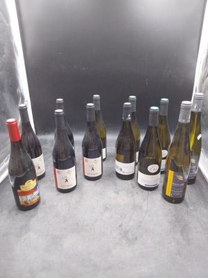 Plusieurs bouteilles de vin sont alignées sur un comptoir
