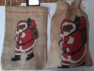 two bags with santa claus on them hanging on a wall