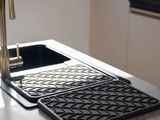a kitchen sink with a black tray and a gold faucet