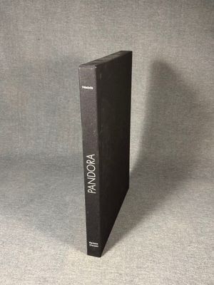 a black book sitting on top of a table next to a gray wall
