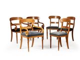 quatre chaises en bois avec des assises rembourrées noires sur fond blanc