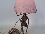 a lamp that has a pink shade on top of it