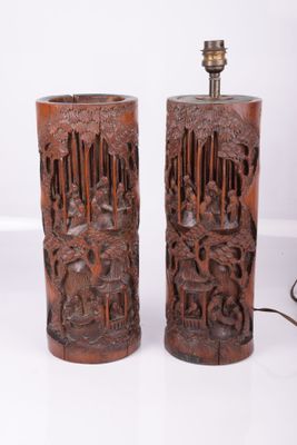 paire de lampes asiatiques en bois sculpté posées sur un support blanc