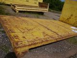 a large piece of metal sitting on the ground next to a dump truck