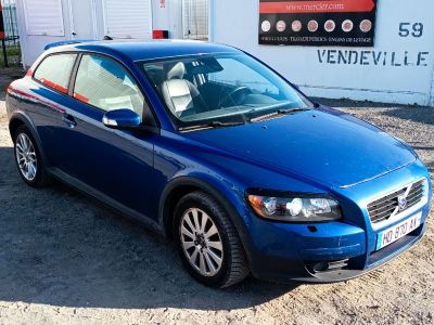 une photo d'une voiture bleue garée devant un immeuble
