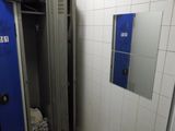 une salle de bains avec une porte bleue et un mur carrelé de blanc