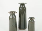 three vases sitting next to each other on a white surface