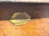 a close up of a wooden box with a brass plate on it