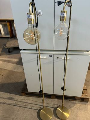 une paire de lampadaires en laiton, chacun muni d'un globe en verre