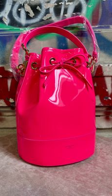 neon pink bucket bag with bow handle and chain strap