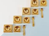 several pieces of gold metal are arranged on a blue and white surface
