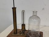 une bouteille en verre posée sur un socle en bois, surmontée d'une autre bouteille en verre