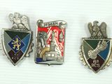 three badges of different colors and designs on a white surface