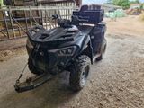 a black atv with a trailer attached to it in a barn