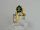 a close up of a ring with a green stone in it