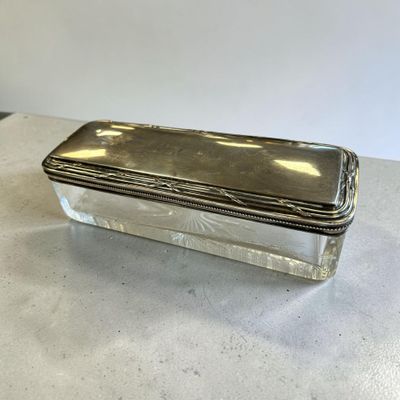 une boîte plaquée argent posée sur une table avec un fond blanc