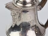 silver plated tea pot with a wooden handle and a lid