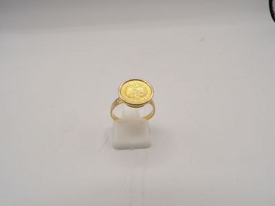 Gros plan sur une bague ornée d'une pièce d'or
