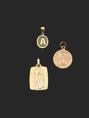 trois pendentifs en or représentant une femme et une médaille sur fond noir