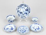 blue and white porcelain dishes and cups and saucers on a stand